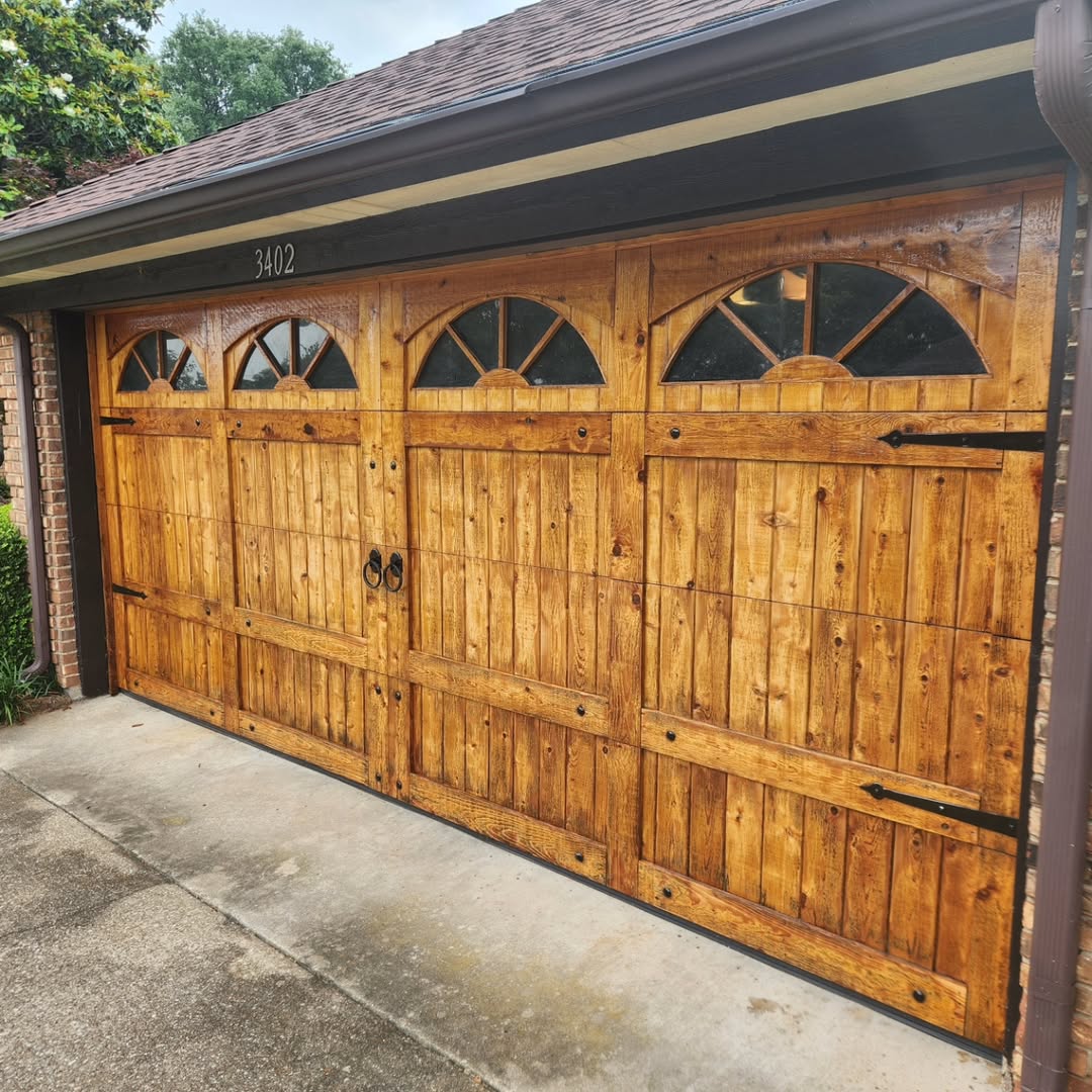 Golden carriage house wood garage door with sunburst windows