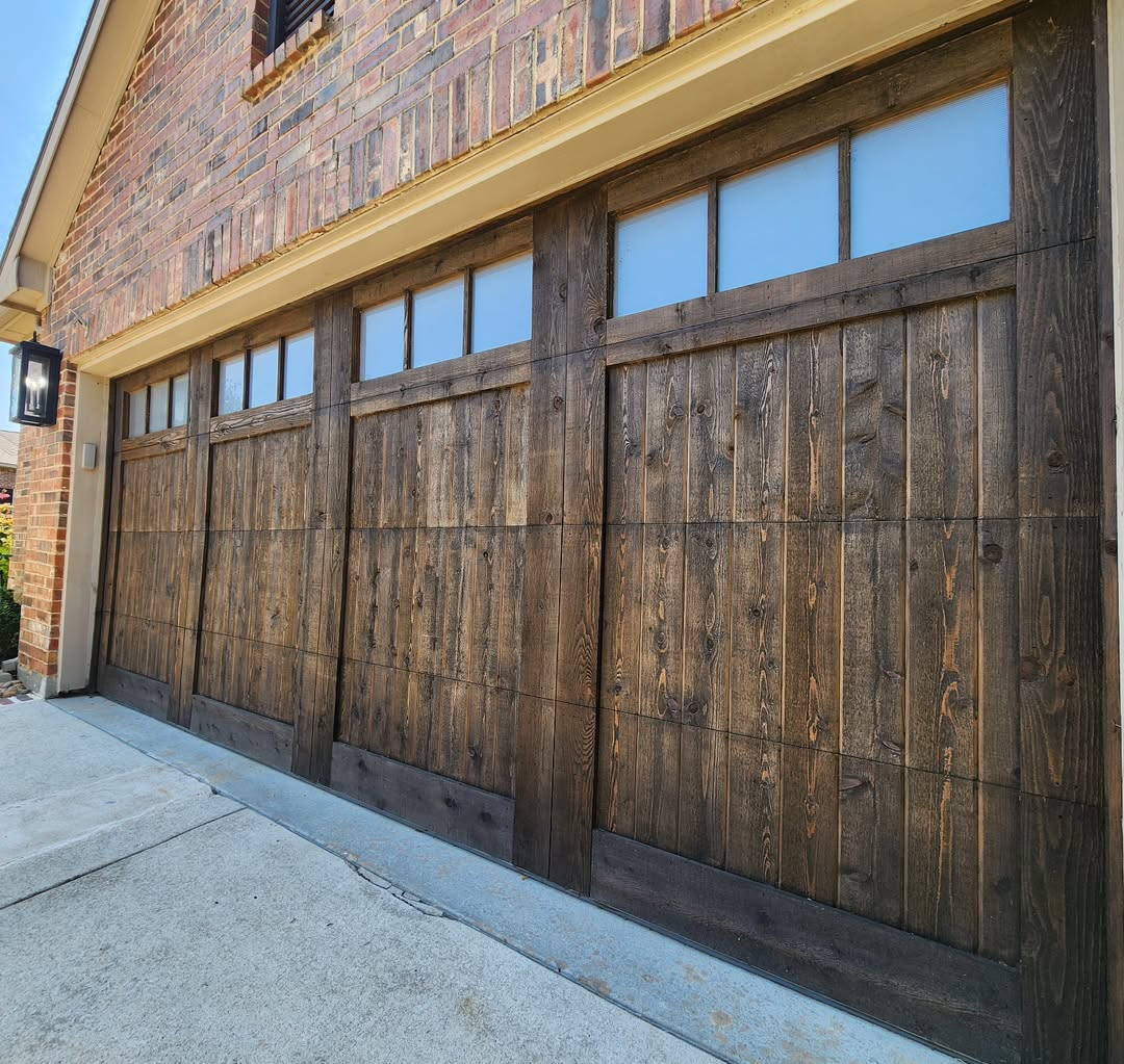 Dark stained cedar carriage garage door on a brick home